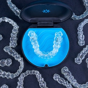 Bird’s eye view of several Invisalign trays around its carrier case