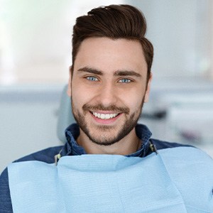 Bearded man sitting in dental chair and smiling