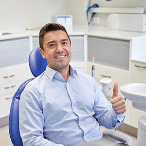 Male dental patient giving a thumbs up