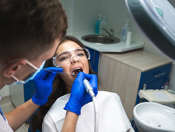 A dentist performing a root canal on a young woman